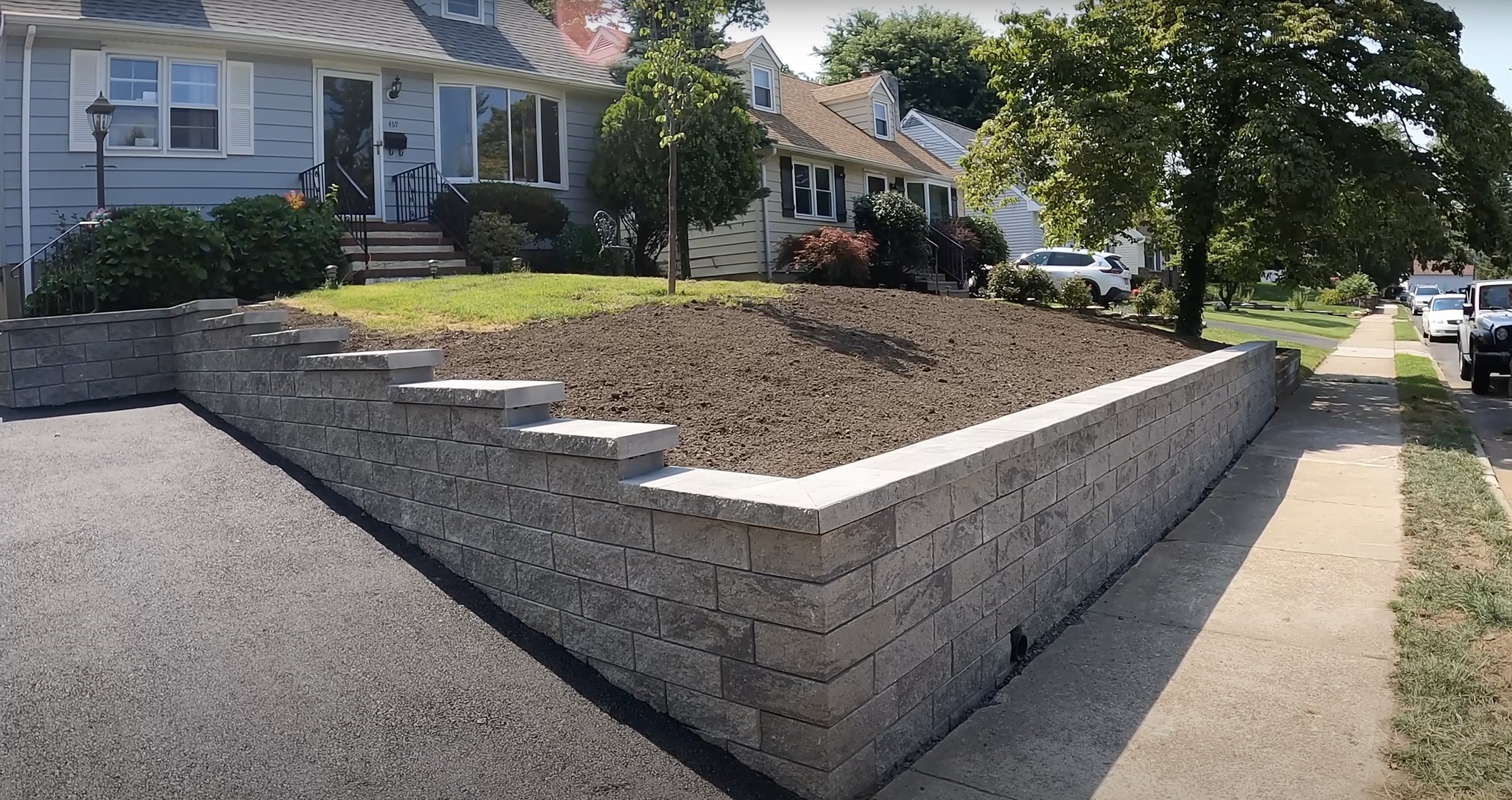 Professional residential concrete work including retaining walls and driveways Completed residential concrete project showing retaining walls and landscaping