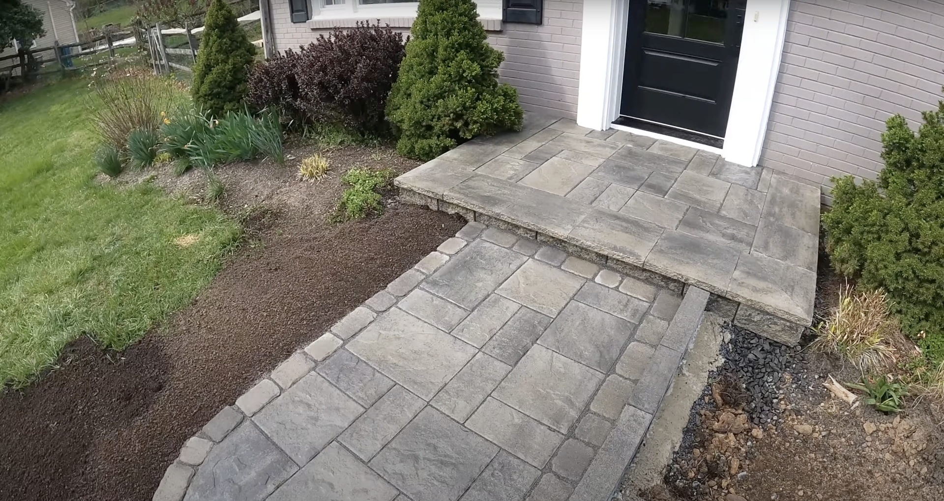 Elegant stamped concrete entrance walkway with professional installation Stamped concrete entrance walkway with decorative pattern leading to front door